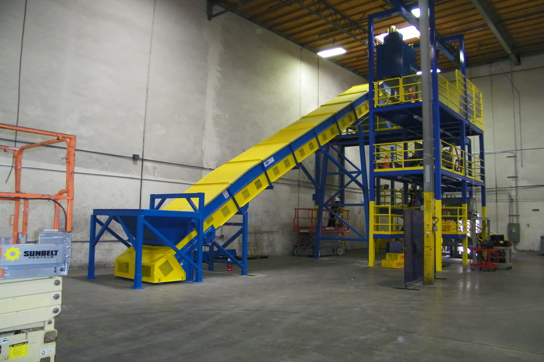 Heavy-duty incline infeed conveyor with hopper installed at a catalytic converter recycling plant