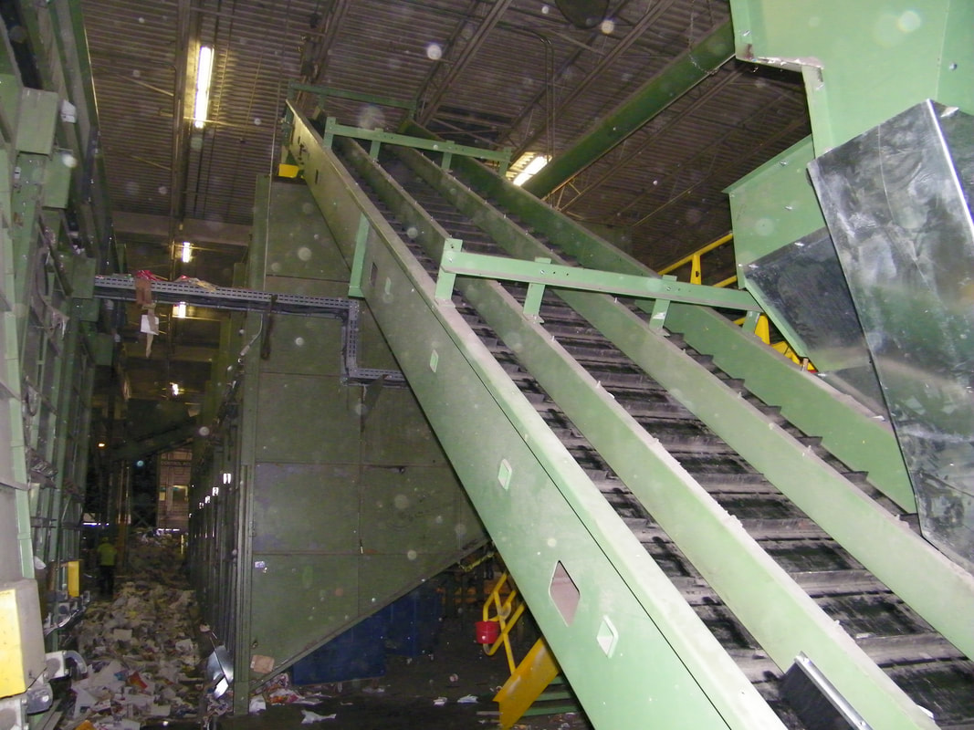 Divided three-lane inclined belt conveyor carrying sorted material away from the optical sorter