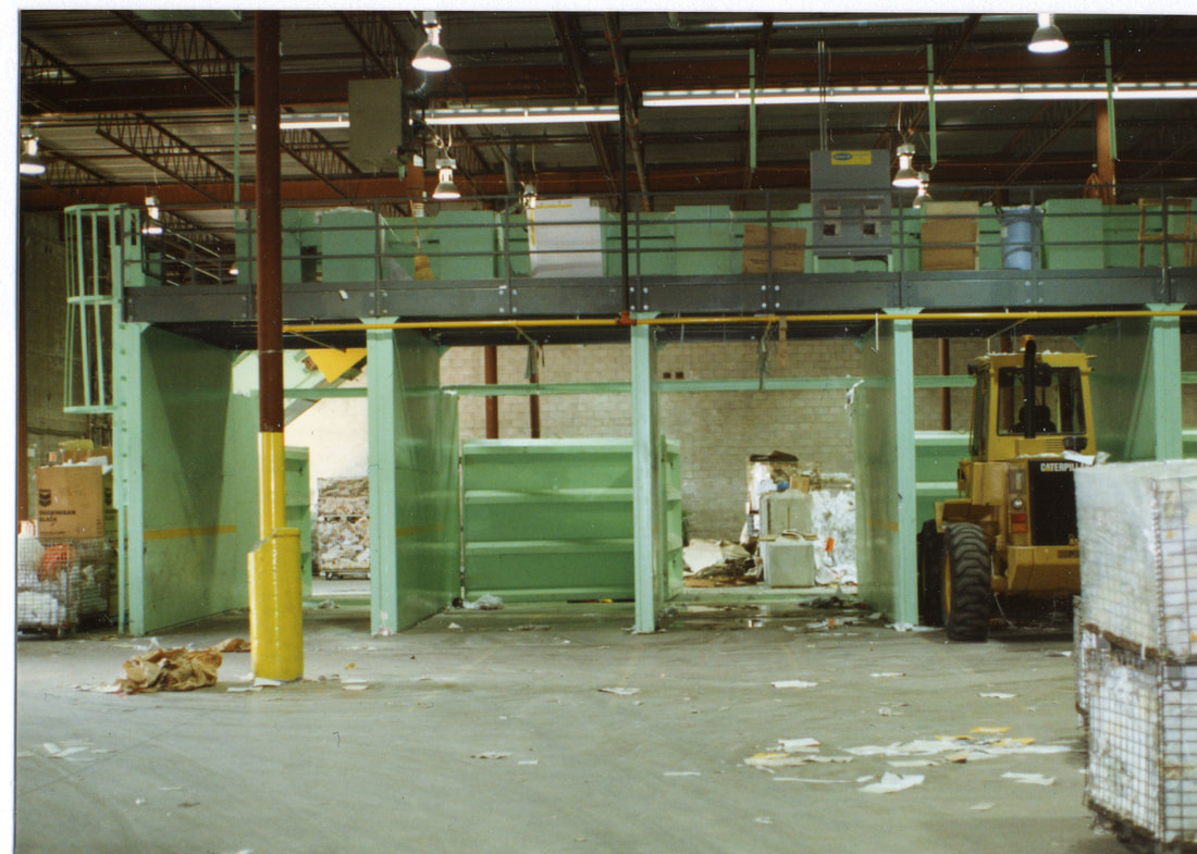 Heavy-duty bunker walls under a sort conveyor, dividing storage for different materials