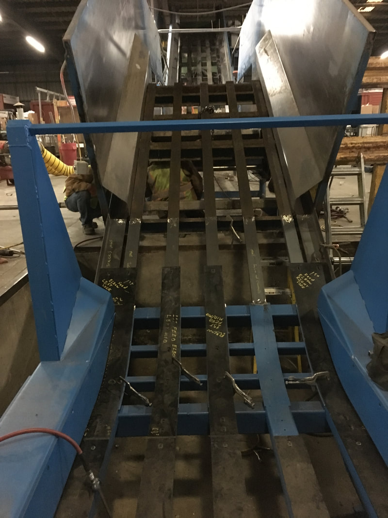 New in-ground conveyor section welded to the old above-ground section, with wear liner plastic being fitted