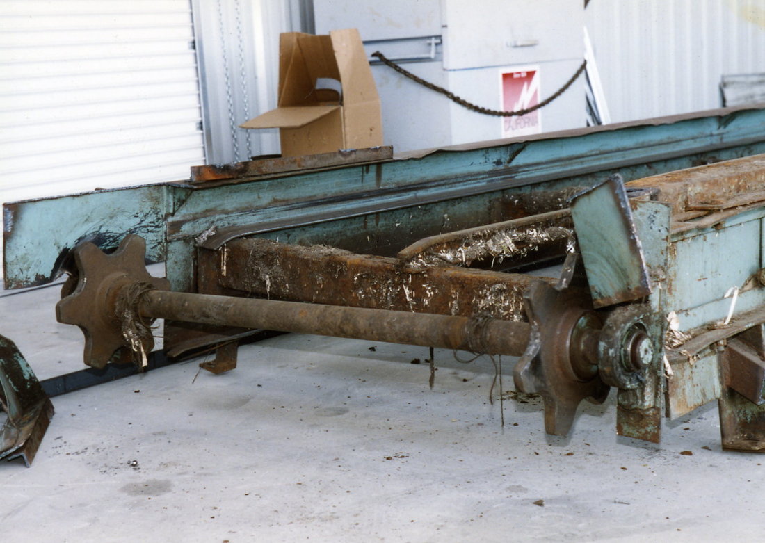 Old worn-out tail section of the in-ground chain belt conveyor with tail sprockets, prior to refurbishing
