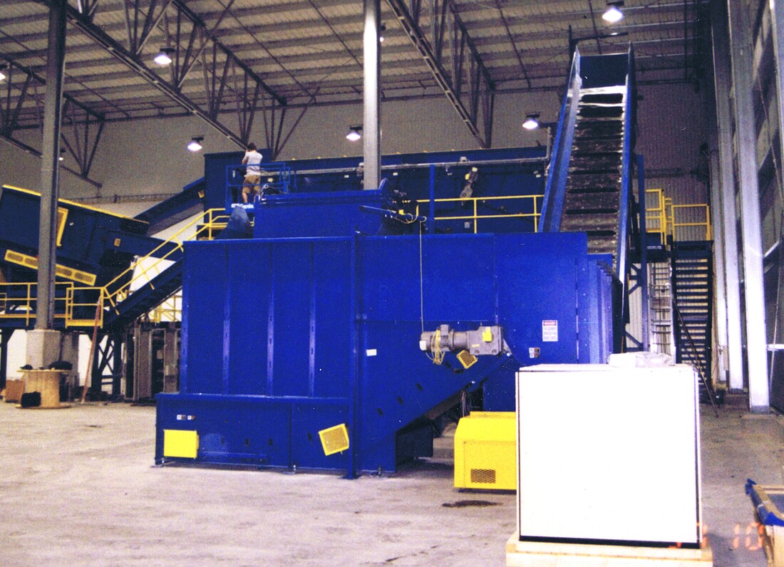 Walking live floor bin, end view, discharging onto a feed conveyor