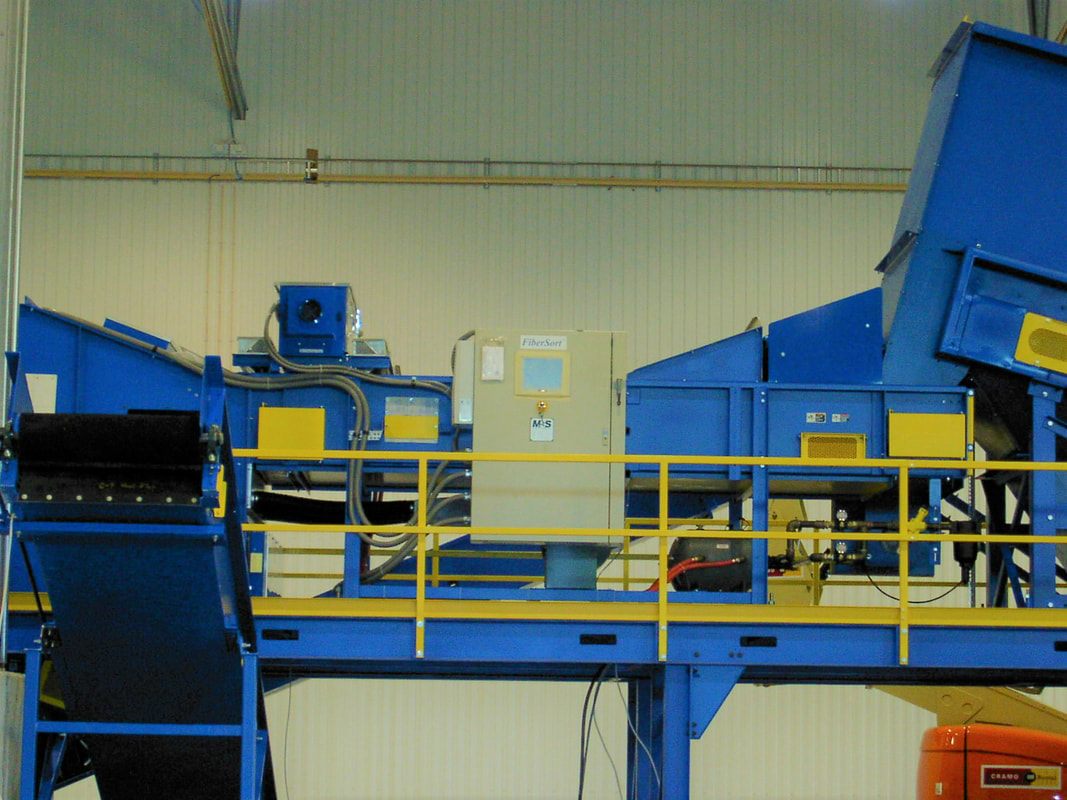 Optical fiber sorting conveyor on a guardrailed platform built and installed by Remcon