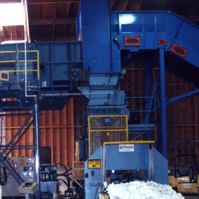 Steel-flight chain belt baler feed conveyor discharging into a baler