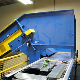 Drag chain conveyor with steel cleats inclining material up to a sort line