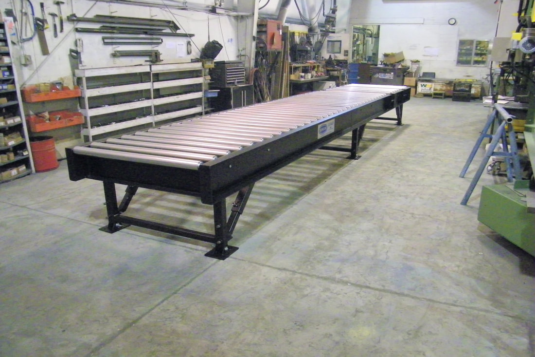 Heavy-duty roller conveyor with drop-in, spring loaded idler rollers and adjustable legs