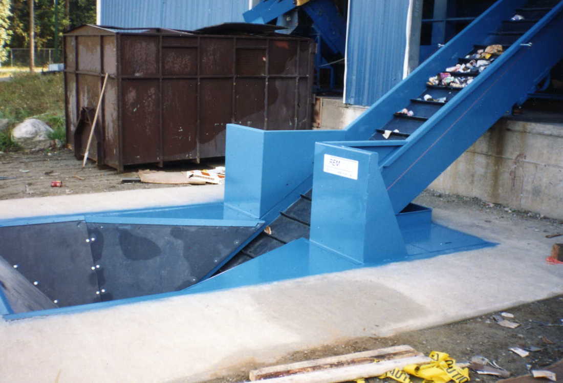 Remcon slider bed infeed conveyor rising out of an in-ground loading pit
