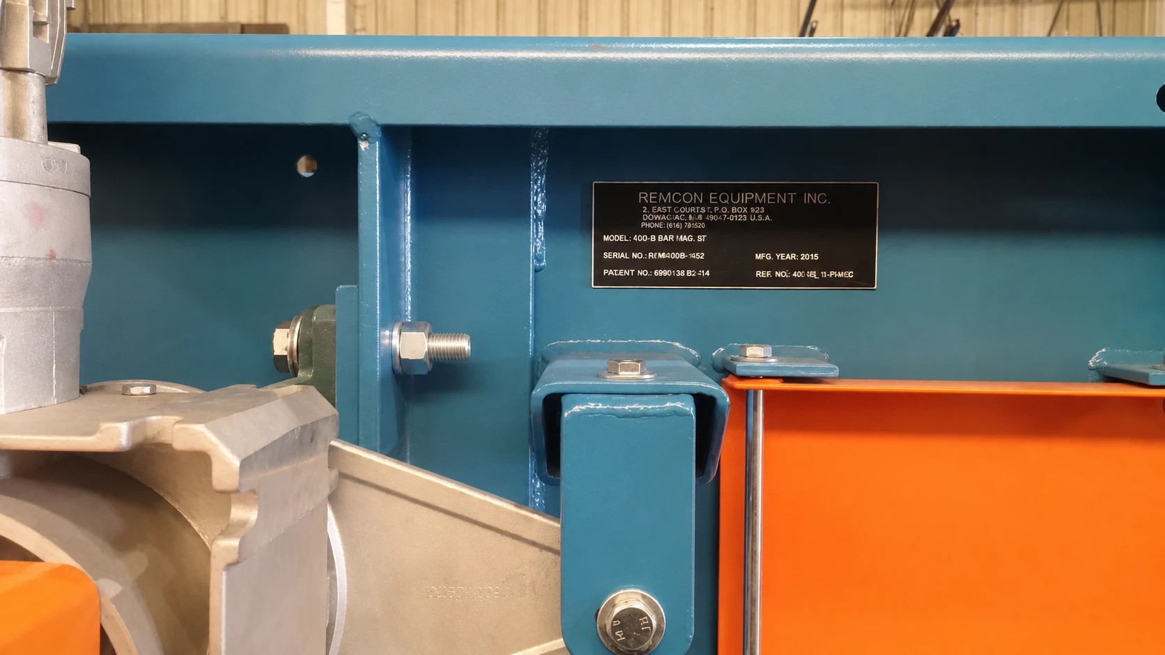 Close-up of a Remcon Equipment nameplate — model 400-B Bar Mag, serial REM400B-1452, mfg. 2015 — on a freshly painted blue frame in the shop