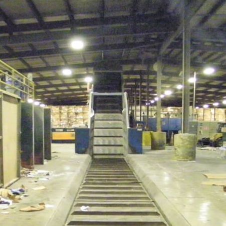 Roller chain infeed conveyor installed in-ground in a pit, end view