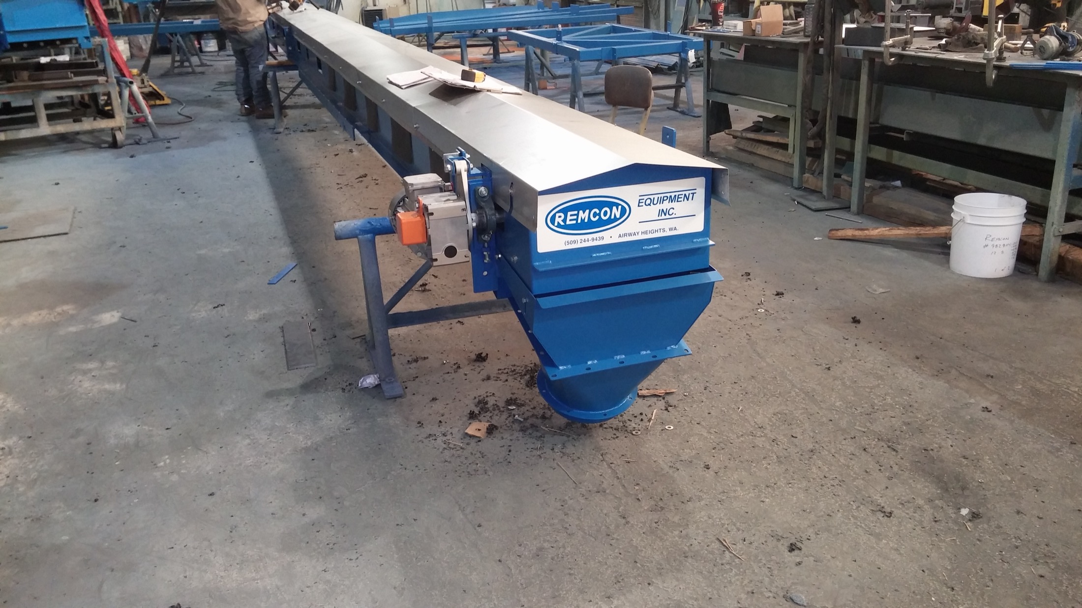 A long Remcon slider bed conveyor with discharge chute in the shop for build and refurbishing