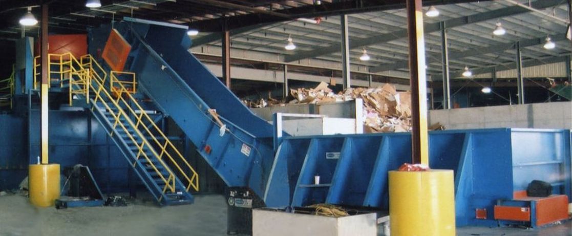 Slider bed sort line feed conveyor with above-ground loading section and pushwall