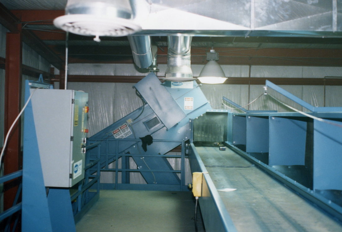 Sorting conveyor with pitch hoppers and drop chutes, fed by a feed conveyor