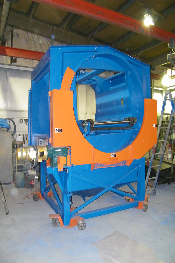 Chain-driven tote dumper with transfer conveyor, showing rotation frame and guarding