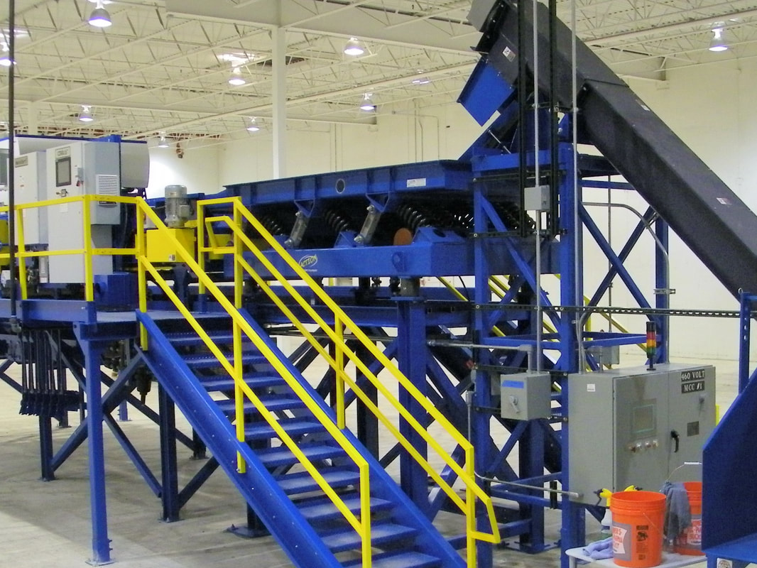 Vibratory feeder installed in a conveyor system for optical sorting